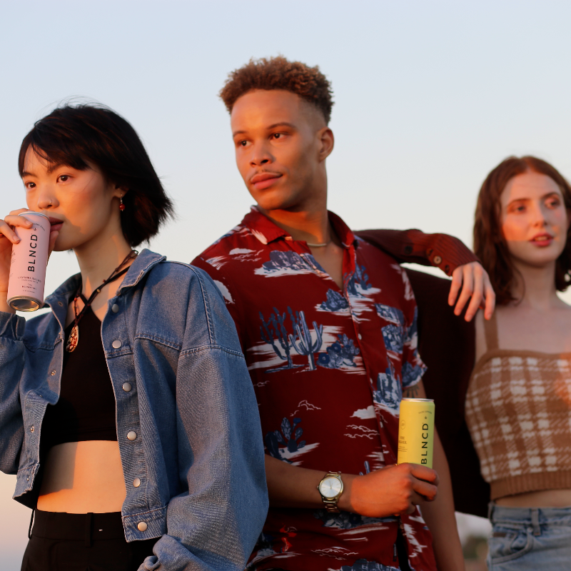 Three people standing together outdoors with drinks in their hands at sechey